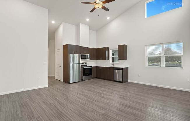 A modern kitchen with a refrigerator, microwave, and oven.