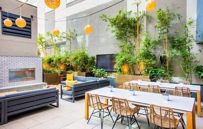 A modern outdoor dining area with a fireplace and seating for multiple people.