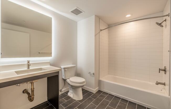 a bathroom with a toilet sink and tub and a mirror