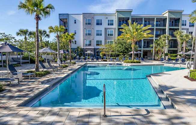 a swimming pool with an apartment building in the background