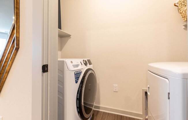 A white washing machine is in a laundry room.