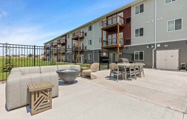 our apartments have a large patio with furniture and a fire pit