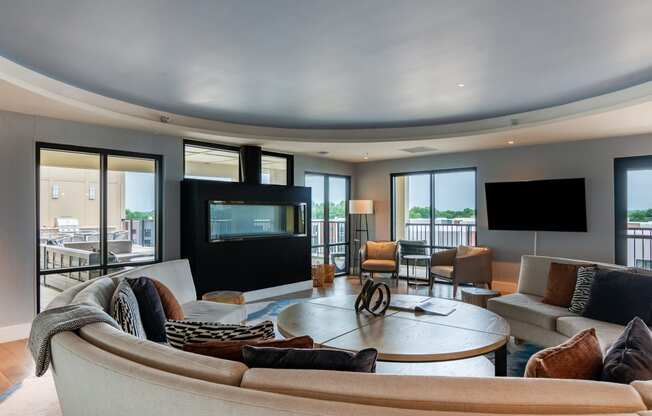 a living room filled with furniture and a flat screen tv  at Century West Pryor, Lee's Summit, MO