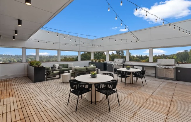 A patio with a table and chairs is set up on a wooden deck.