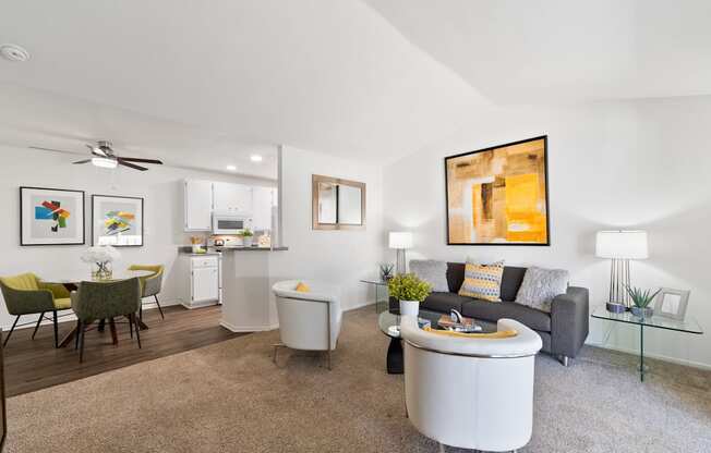 a living room with a couch and a coffee table and a kitchen in the background