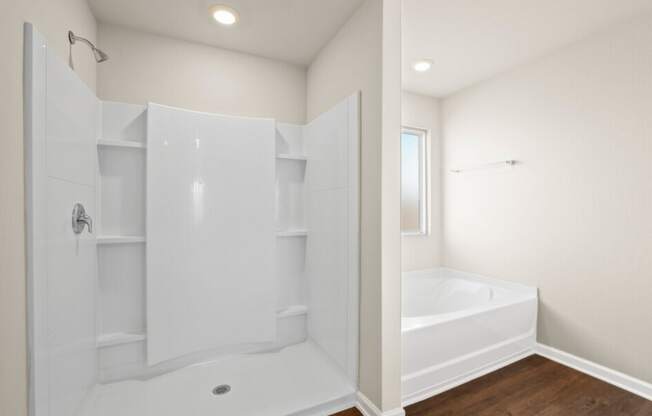 a white bathroom with a tub and shower and a closet