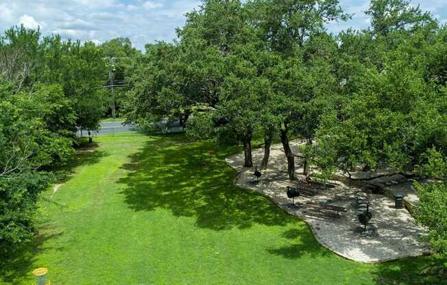 A green lawn with trees and a yellow object.