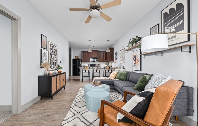 a living room with a couch and a chair and a ceiling fan