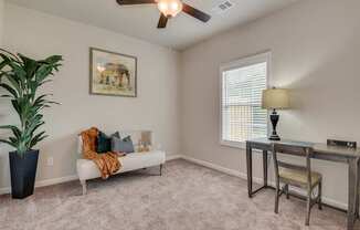 a living room with a couch and a table and a ceiling fan