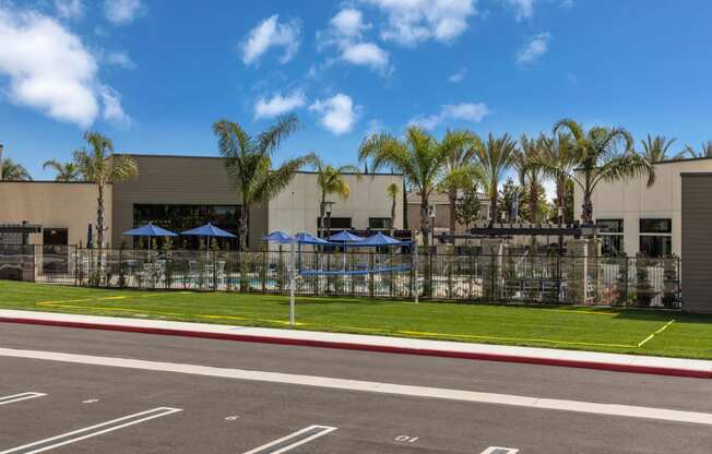 a building with umbrellas and palm trees in front of itat Westbury Apartments, Rancho Cucamonga, CA, 91739