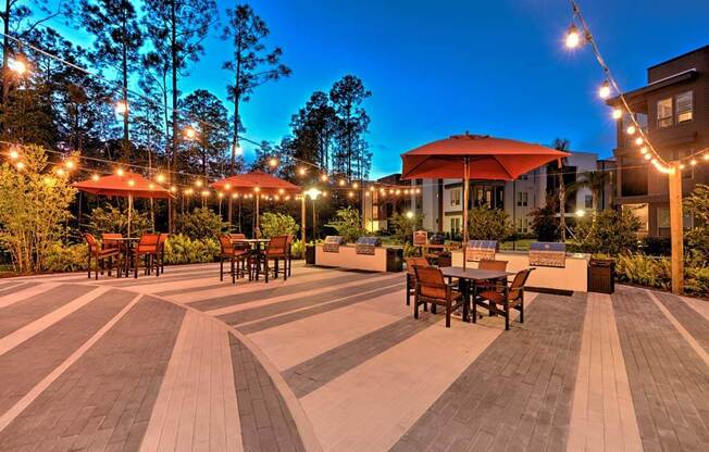 a patio with tables and umbrellas at night at Luxor Club, Jacksonville, Florida