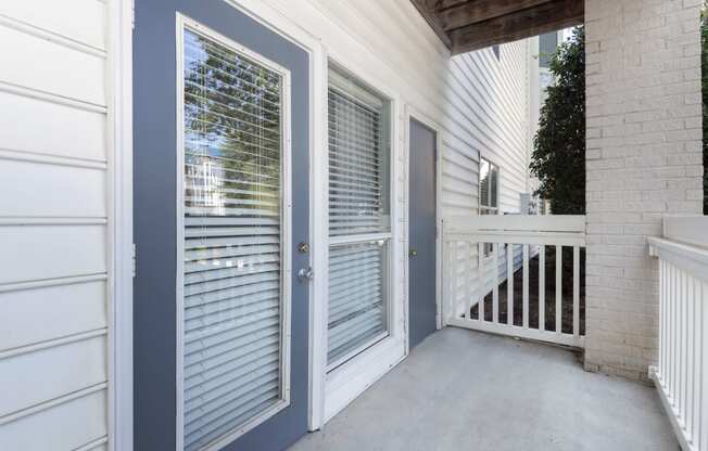 a private patio with a glass door and a porch with a railing at Whitehall Estate apartments in Charlotte NC