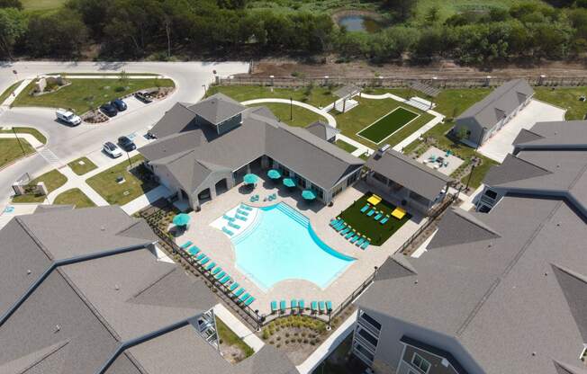 an aerial view of the resort style pool and tennis courts