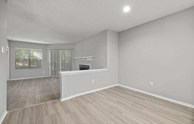 the living room and dining room of an empty house with a fireplace