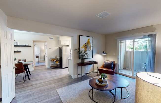 a living room with a sliding glass door leading to a kitchen