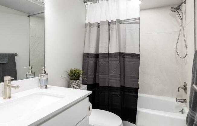 bathroom with large sink and vanity, garden tub, and mirror