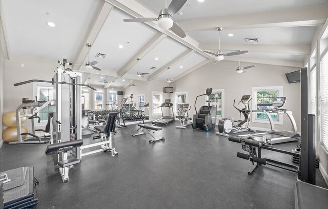 A spacious gym with various exercise equipment and a ceiling fan. at Somerset Oaks Apartment Homes, Olathe, Kansas