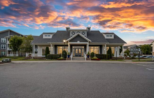 the front of a house with a sunset in the sky