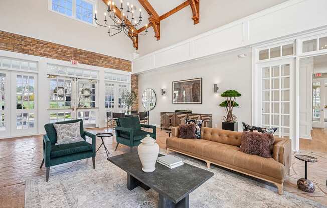 A living room with a brown couch, green chairs, and a coffee table.