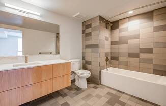 A bathroom with a white tub, sink, and toilet.