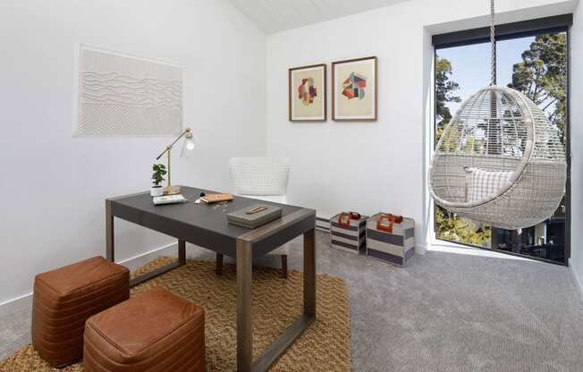 a living room with a table and a chair and a window