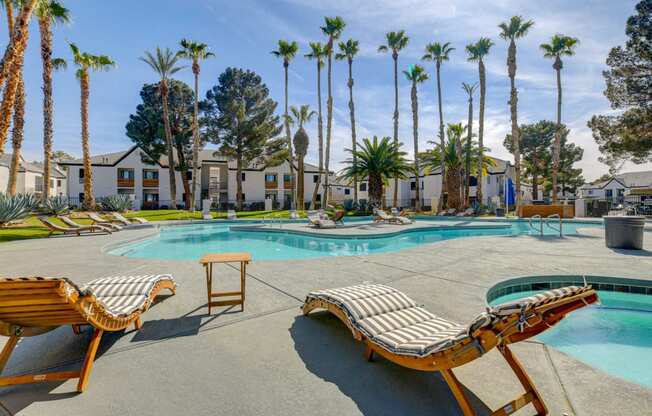 a pool with lounge chairs and palm trees in the background