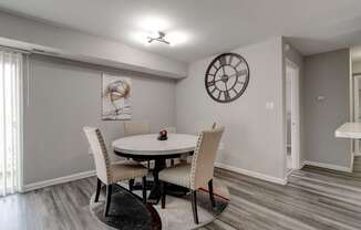 A dining room with a round table and chairs.