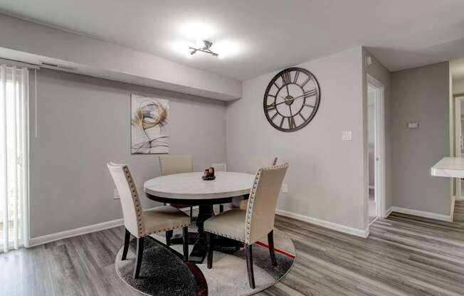 A dining room with a round table and chairs.
