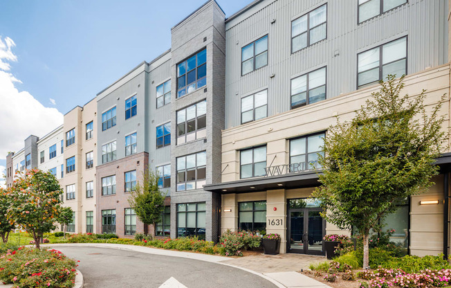 A modern apartment building with a white arrow on the road in front.