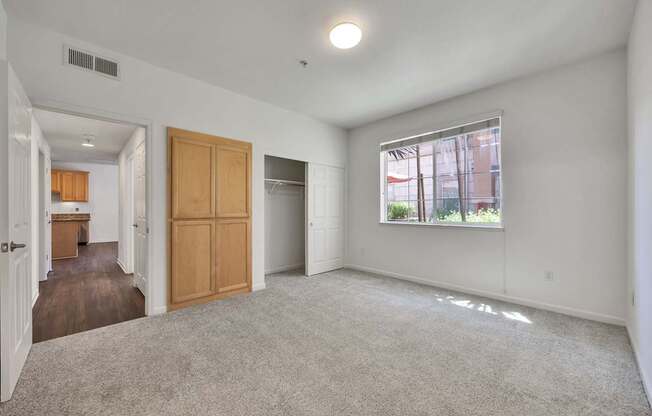 an empty living room and kitchen with a large window