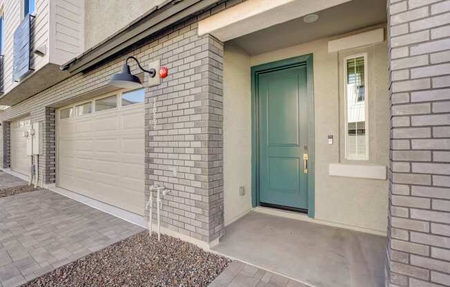 A house with a blue door and a grey garage door.