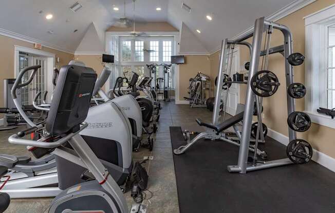 A gym with treadmills, elliptical machines, and weightlifting equipment.