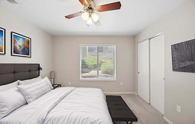 A bedroom with a large bed and a ceiling fan.