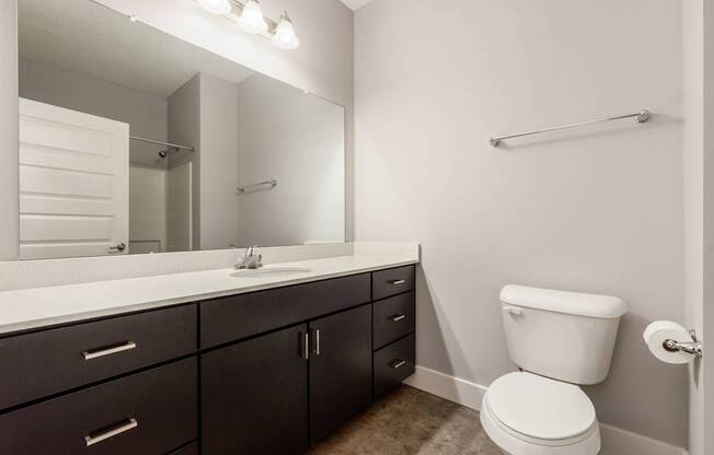 A white toilet sits next to a sink in a bathroom.