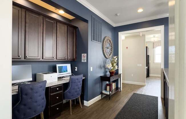 Stylish business center at Queens Gate Apartments featuring modern workstations, comfortable seating, and a sleek design—perfect for remote work and productivity