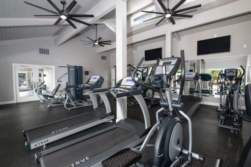 Fitness center with cardio equipment and televisions