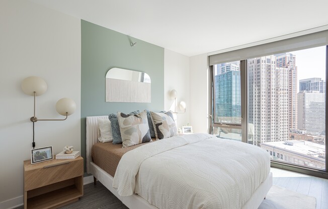 A bedroom with a large bed and a view of the city.