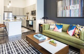 a living room and kitchen with a couch and a coffee table