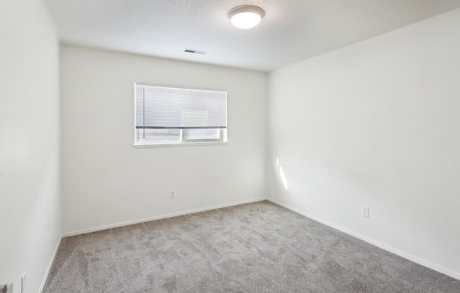 an empty room with white walls and a window