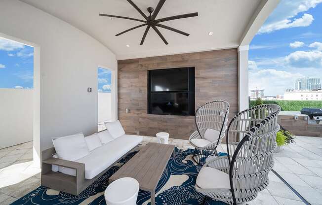 a living room with a couch and chairs in front of a tv at Altis Grand Central, Florida, 33606