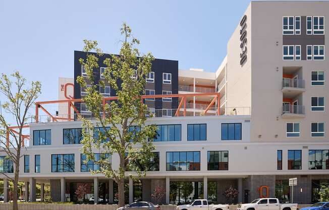 A modern building with a parking lot in front.