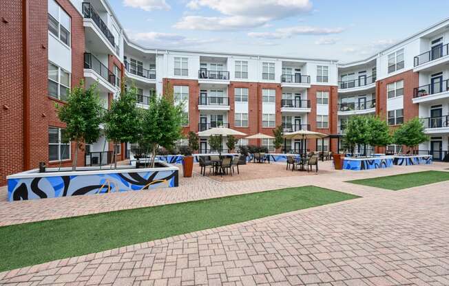 Spacious outdoor courtyard with brick pathways and greenery at The Grand at Upper Kirby apartments in Houston, TX