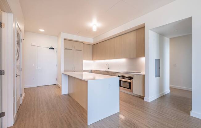 A kitchen with a white island and wooden floors.