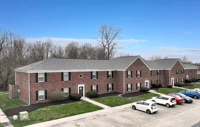 A large brick building with a parking lot in front.