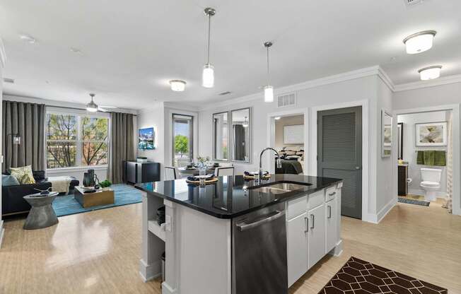 A modern kitchen with a black countertop and stainless steel appliances.
