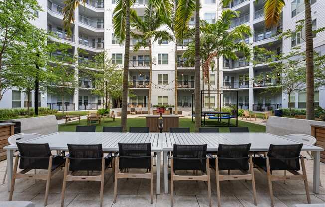 a large table and chairs in a courtyard at an apartment building