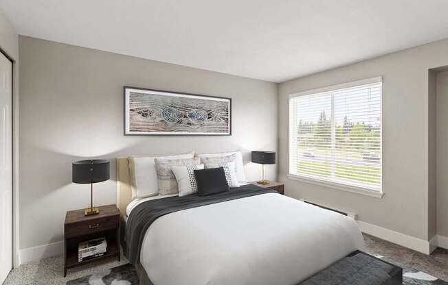 A bedroom with a large bed, a nightstand with a lamp, and a framed picture on the wall.