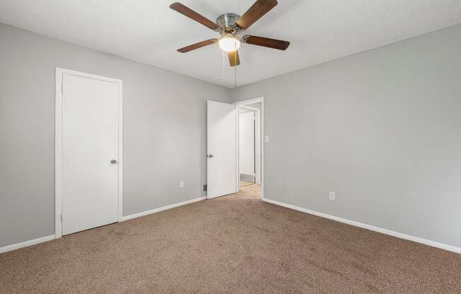 an empty living room with a ceiling fan