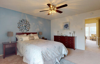 a bedroom with a bed and a ceiling fan