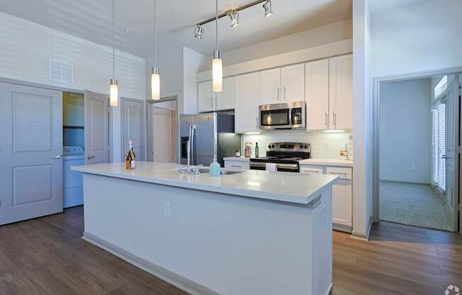 A kitchen with a white island and a refrigerator.